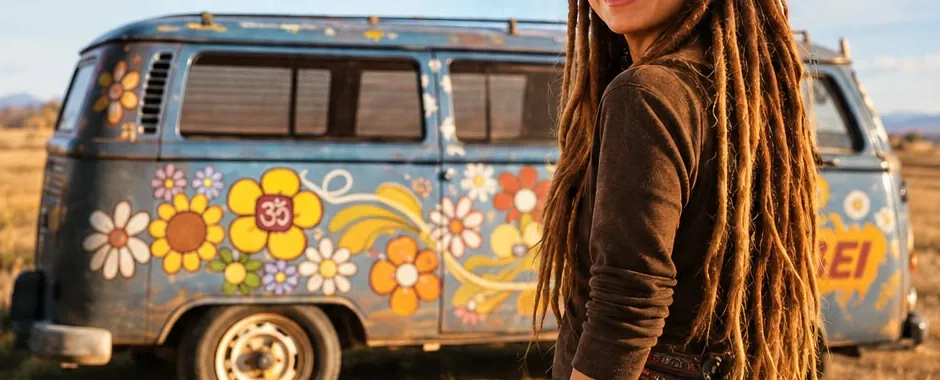 Ilustración de Nae con dreads largos junto a una combi pintada con flores